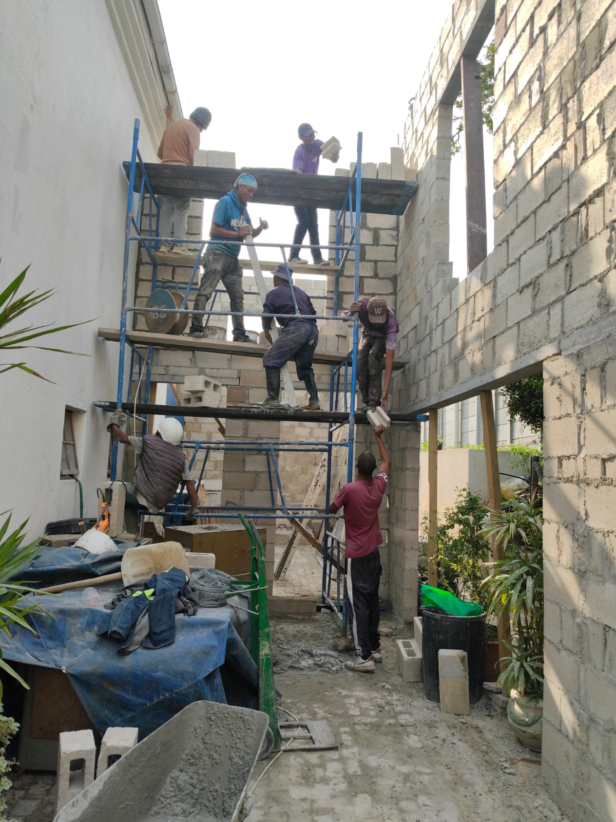 Builders passing blocks up the scaffolding
