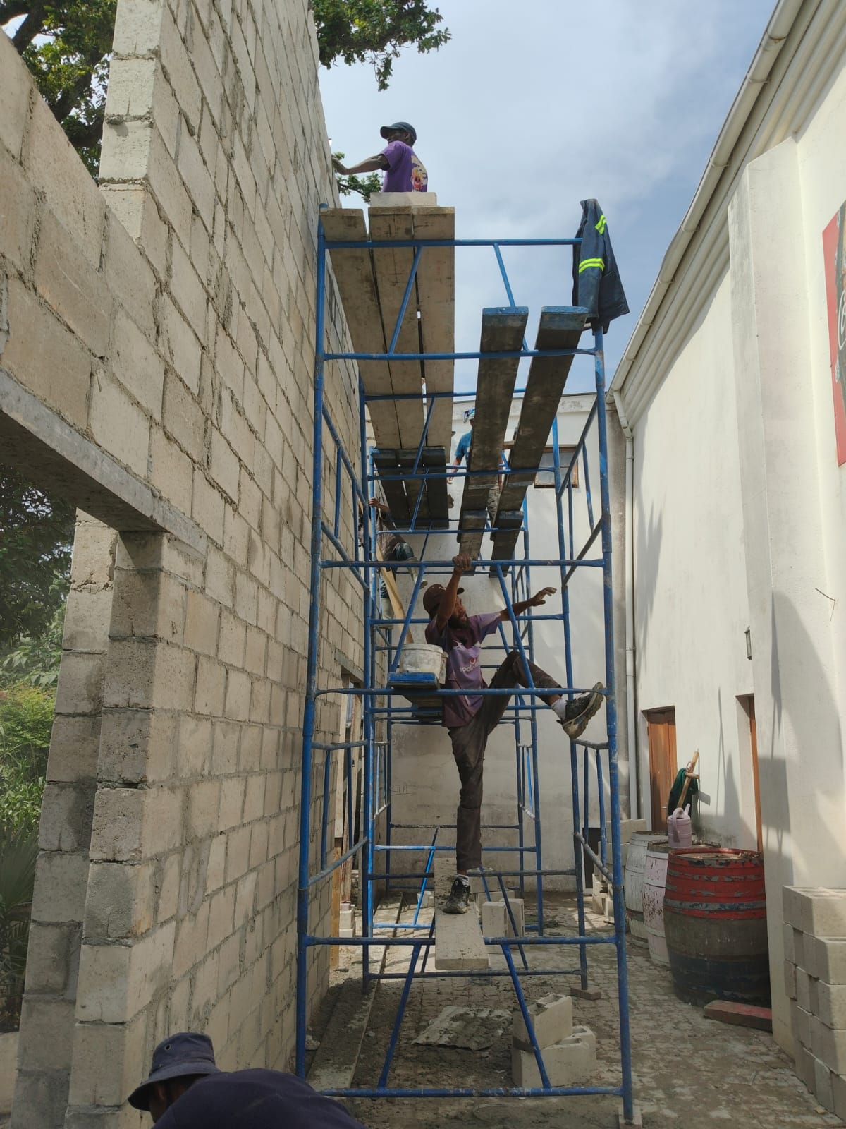 Builder climbing the scaffolding beside the new walls